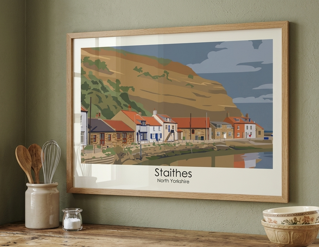 Framed Staithes Harbour poster displayed in a contemporary interior setting, featuring the North Yorkshire fishing village and coastal cliffs.